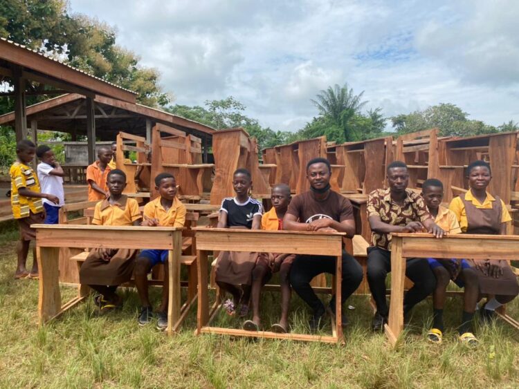 Reg. Minister donates 60 desks to Asiedukuma Basic Sch after students were captured sitting on blocks
